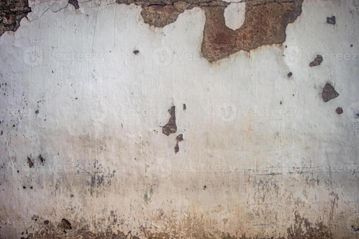 Old, weathered wall with peeling paint and exposed brick, showing signs of decay and neglect, perfect for backgrounds or textures photo