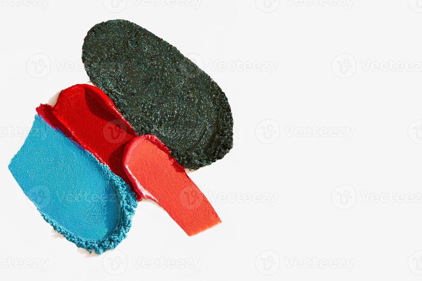 Bright makeup texture composition featuring lipstick, eyeshadow, bronzer, glitter, and powder with empty space on a light white background. photo