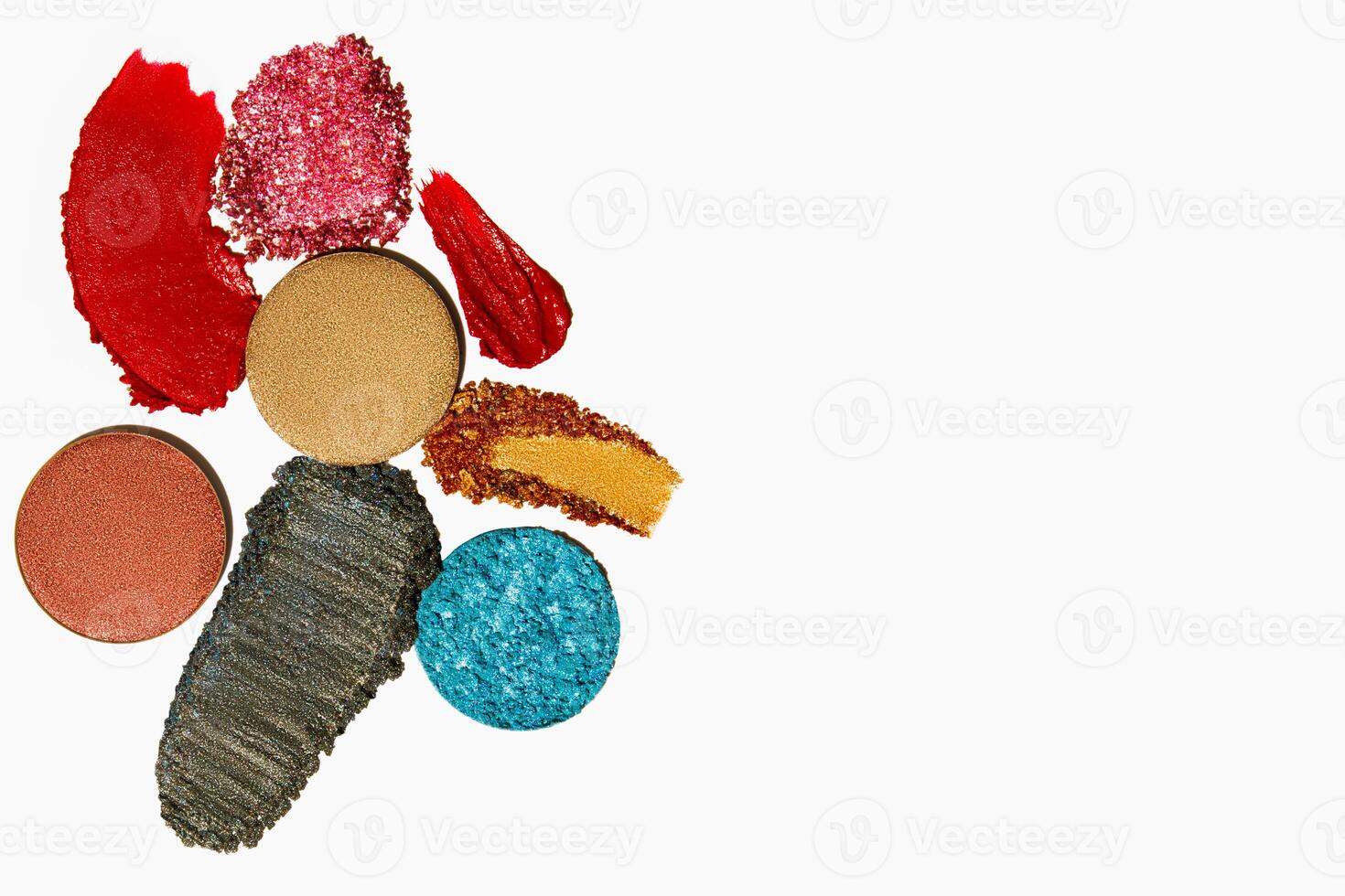 Vibrant cosmetic texture composition of lipstick, eyeshadow, bronzer, glitter, and powder with empty space on a light white background. photo