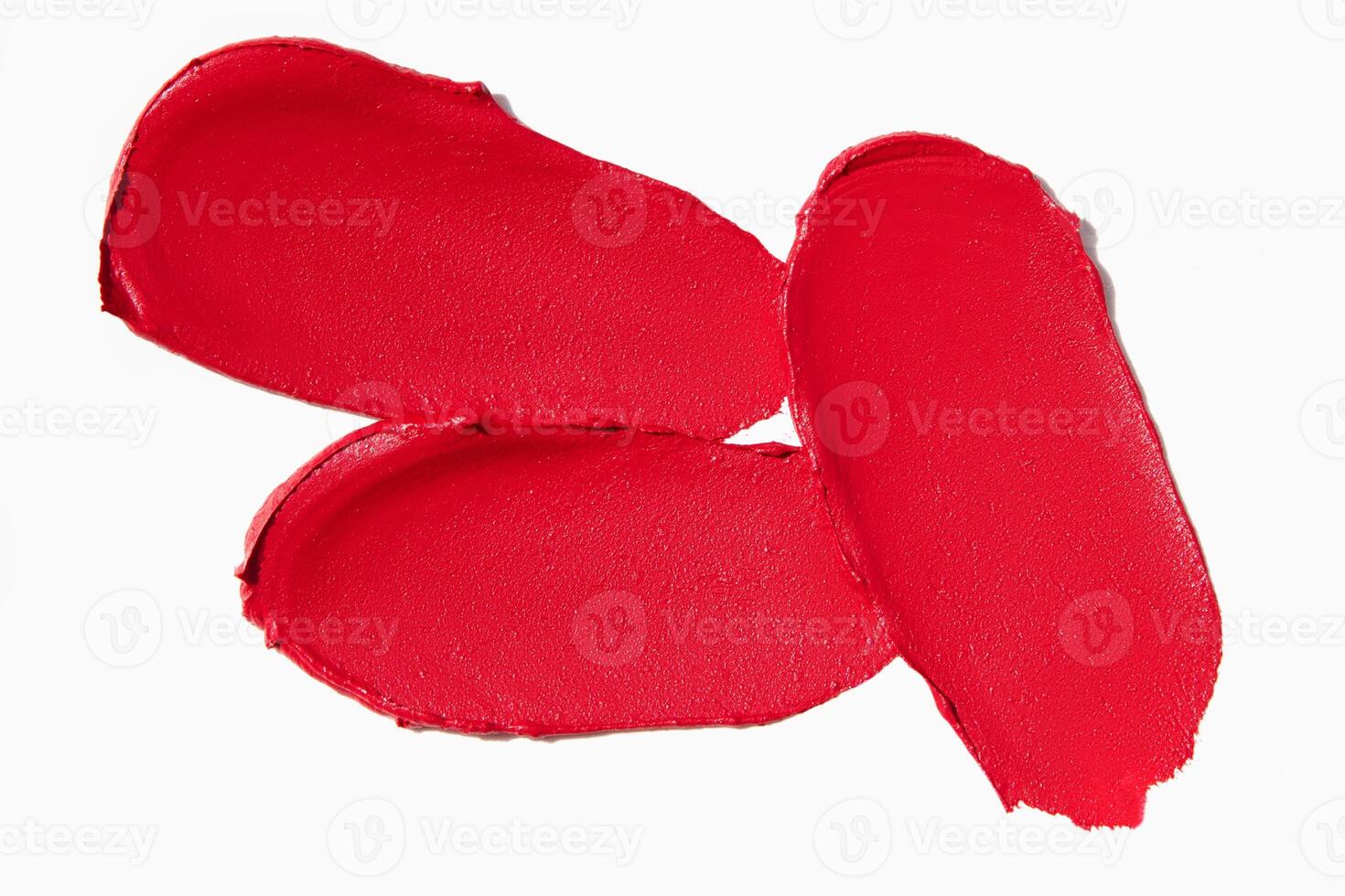 Matte red lipstick smears and cut lipstick textures on a light white background. Cosmetic product swatch sample. photo