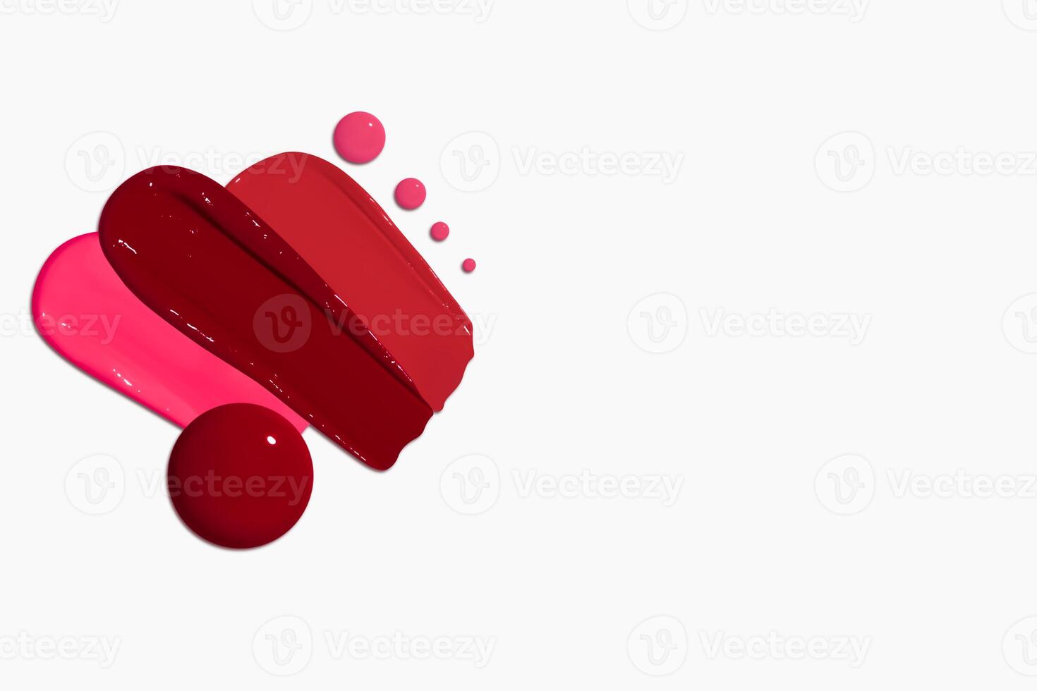 Composition of red lipstick smears and drops in various shades, including dark red, light red, burgundy, and pink, isolated on a light background. photo