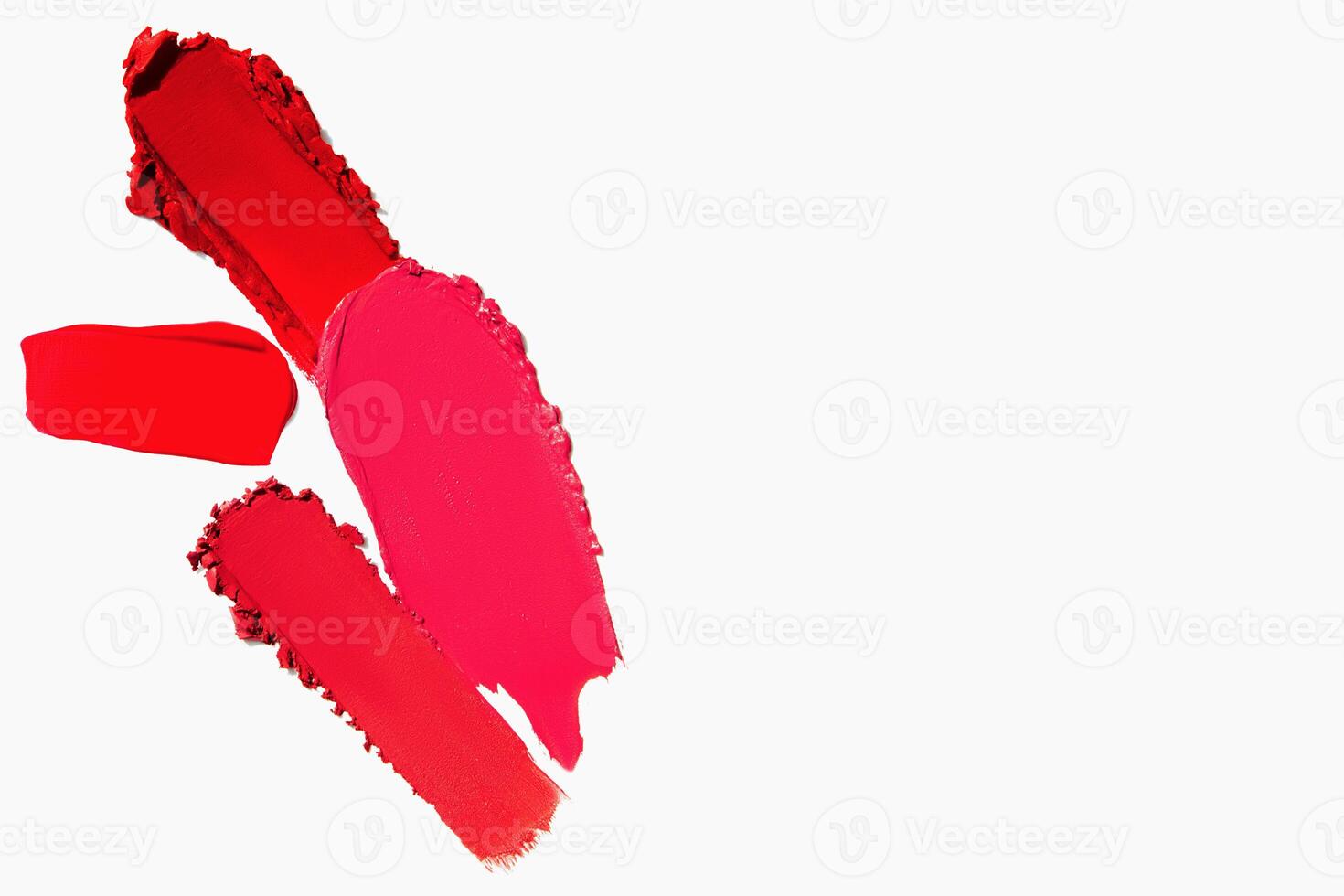 Lipstick texture and swatches in matte red shades with empty space on a light white background. Makeup smear composition. photo