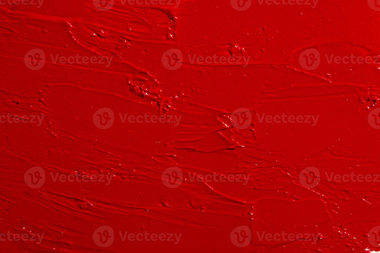 Texture of red lipstick covering the entire image. Bold cosmetic background, rich color. photo
