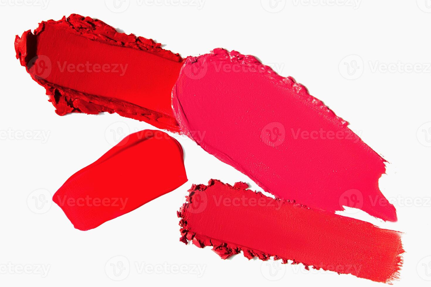 Lipstick strokes in red shades on a light white background. Cosmetic texture of matte lipstick smear. photo