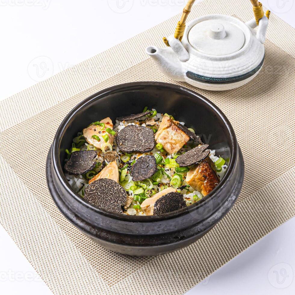 Black Truffle and Foie Grass Rice Donburi topped with fresh scallions served in broth with Teapot isolated on napkin side view of chinese food on white background photo