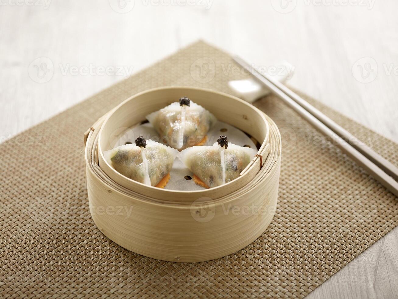 Steamed Black Truffle and Mushroom Dumpling served in a wooden bowl side view on grey marble background photo