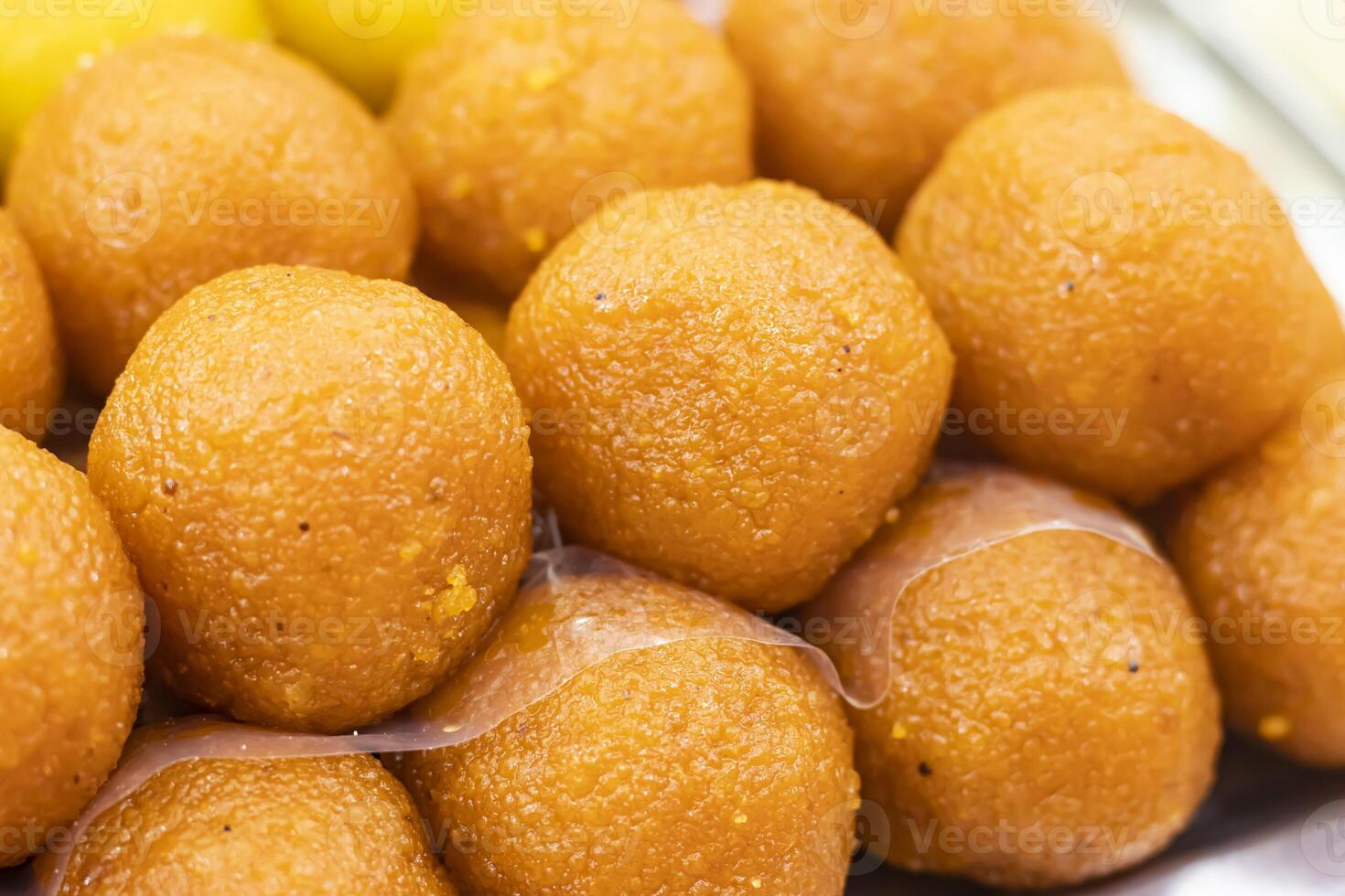 Orange Laddu texture closeup side view of Indian, pakistani and bangladeshi sweet dessert food photo