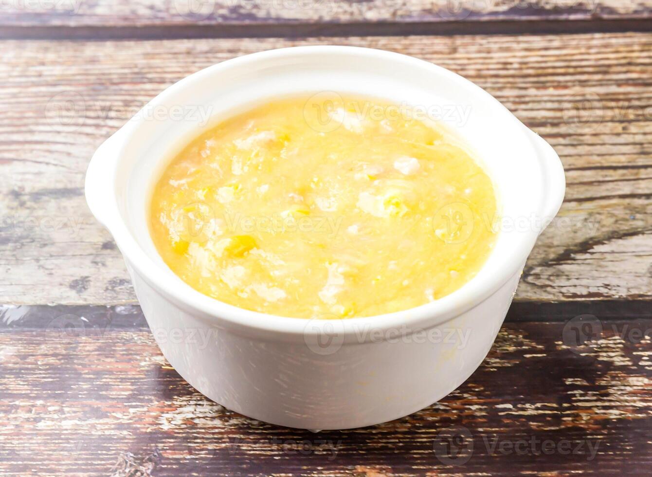 Chicken and corn soup served in broth isolated on wooden table side view of hong kong food photo