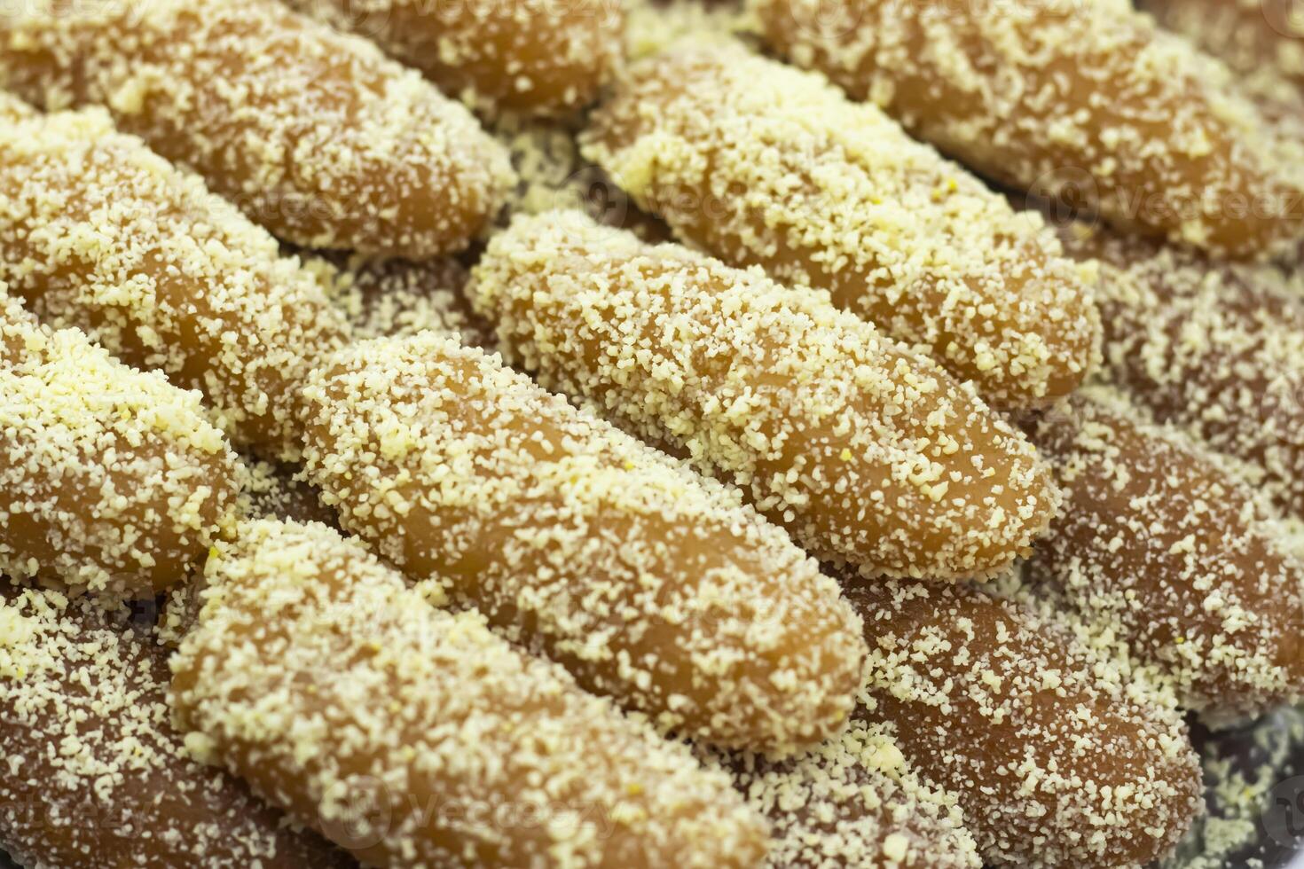 Lal Langcha, Lencha, Lengcha or Lemcha coating with coconut texture closeup side view of Indian, pakistani and bangladeshi sweet dessert food photo