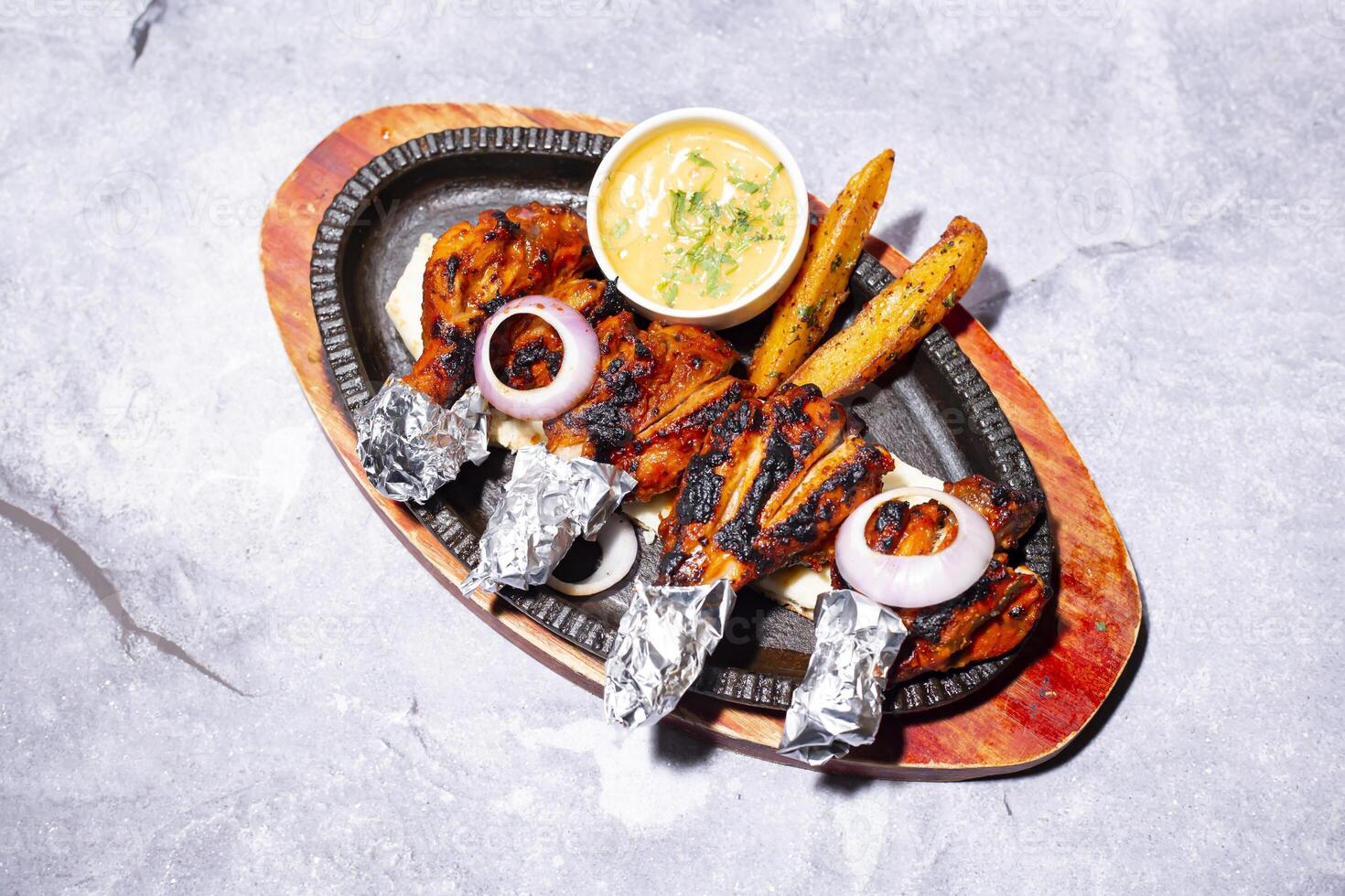 Chicken Tangdi kabab with naan bread, mayo dip, onion and fries served on a sizzling plate isolated on grey background side view of indian, bangladeshi and pakistani bbq food photo