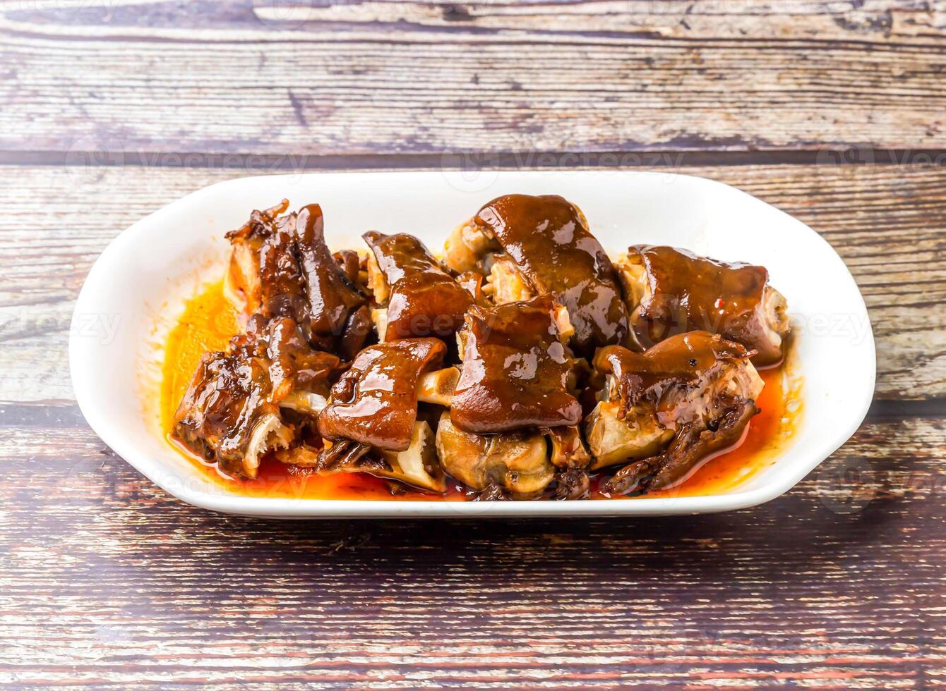 Sichuan Wine Pork Knuckle served in tray dish isolated on wooden table side view of hong kong food photo