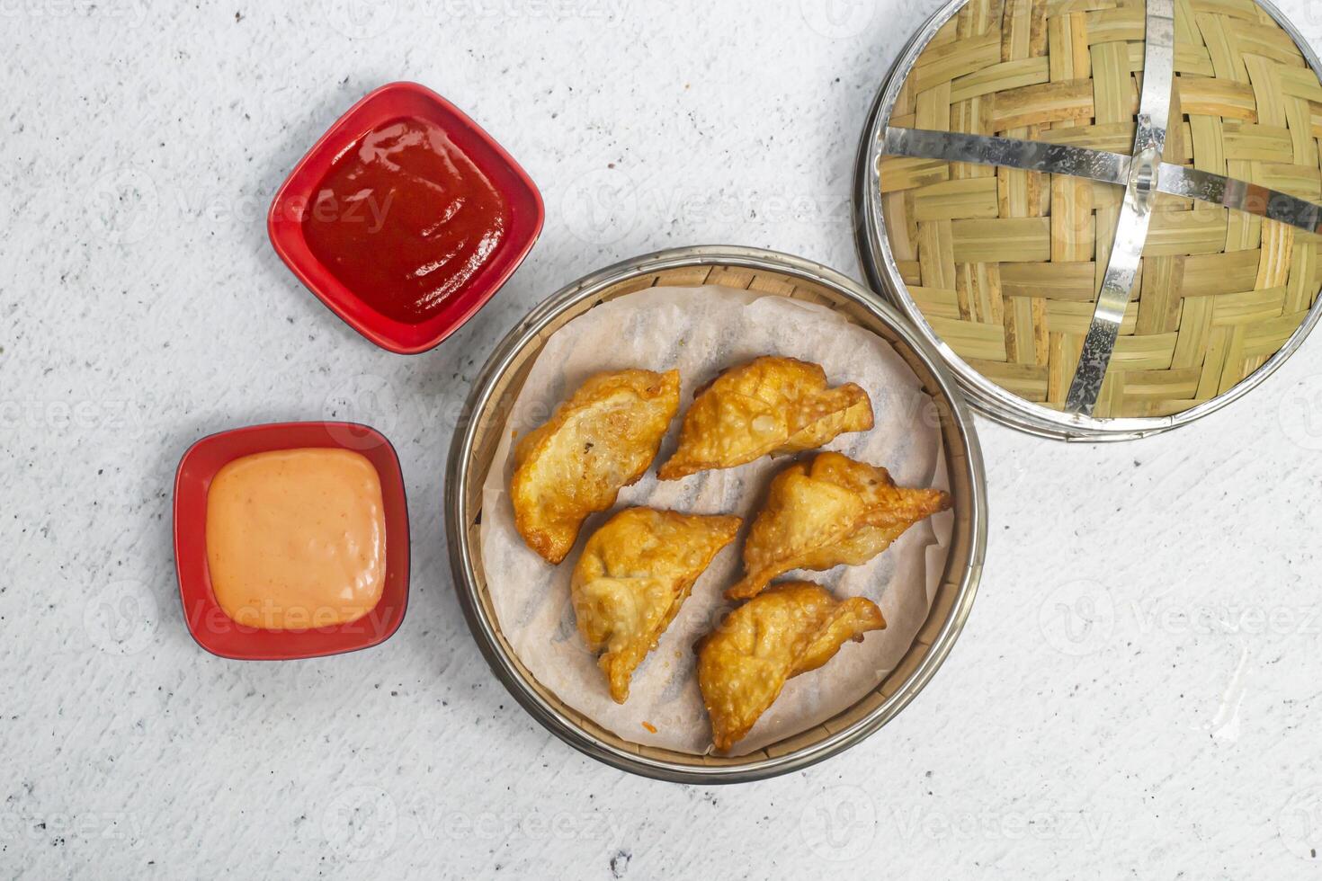 Fried Chicken Cheese Mushroom Momo or Dumplings with mayo dip and tomato sauce served in bamboo steamer isolated on white background top view of bangladeshi, indian and chinese dim sum food photo