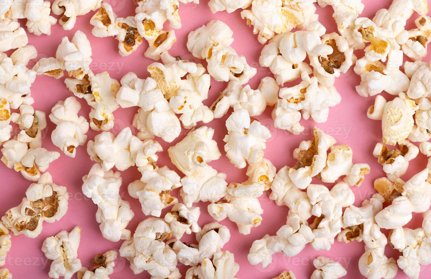 Popcorn on Pink Background. Snack when watching a movie. Flat lay with copy space photo
