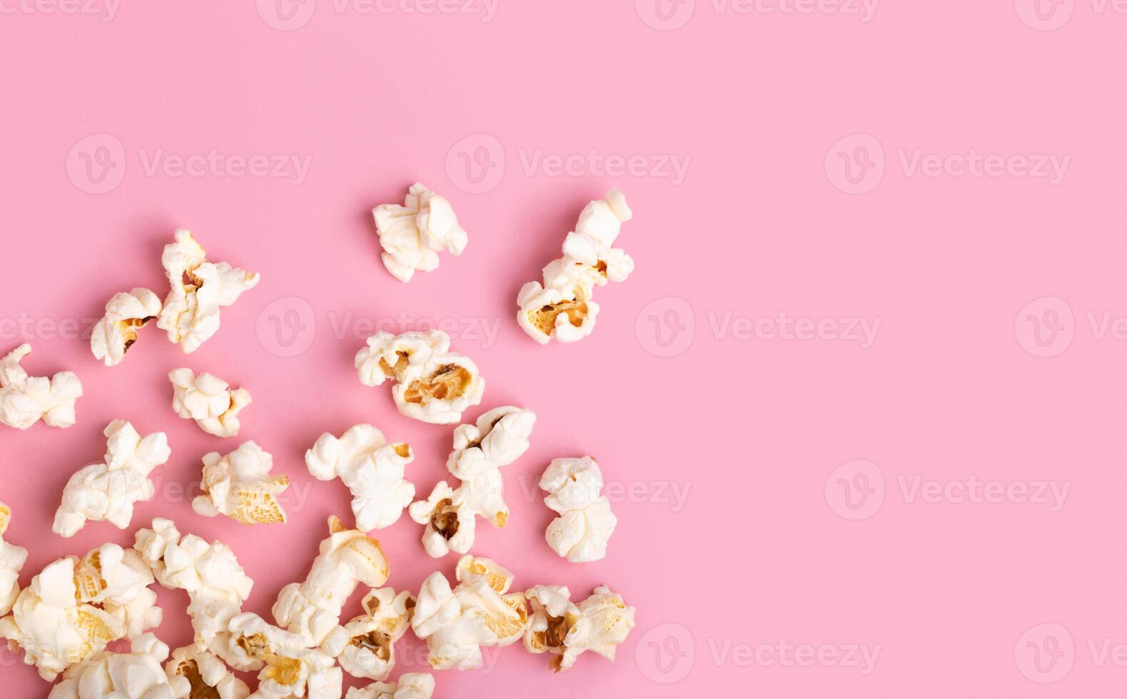 Popcorn on Pink Background. Snack when watching a movie. Flat lay photo