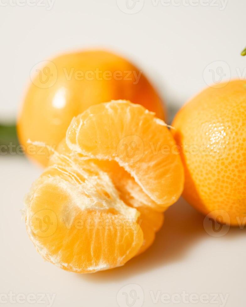 oranges and tangerines with leaves whole and in size lie on a white background photo