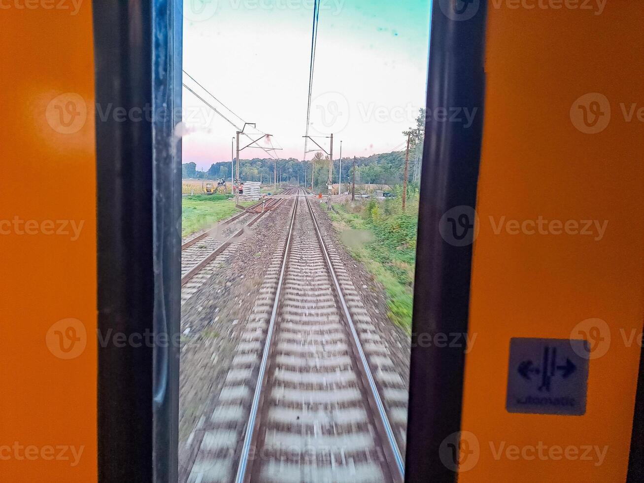 railroad tracks in the countryside, train track under blue sky, electric cables photo