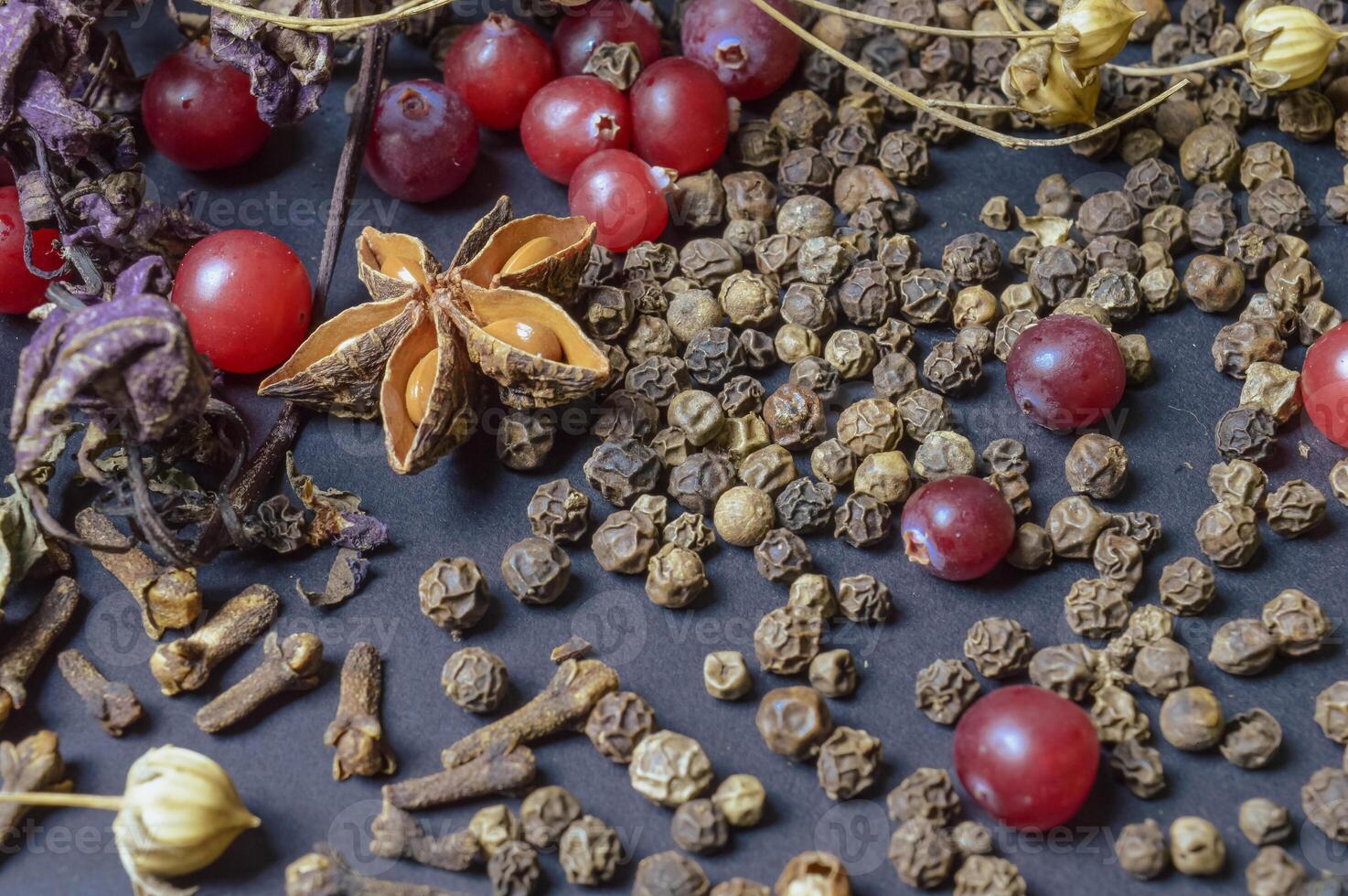 various spices scattered on a dark background with bunches of grass, laurel leaves, berries and other spices for cooking fragrant Eastern and Midwestern food. High quality photo