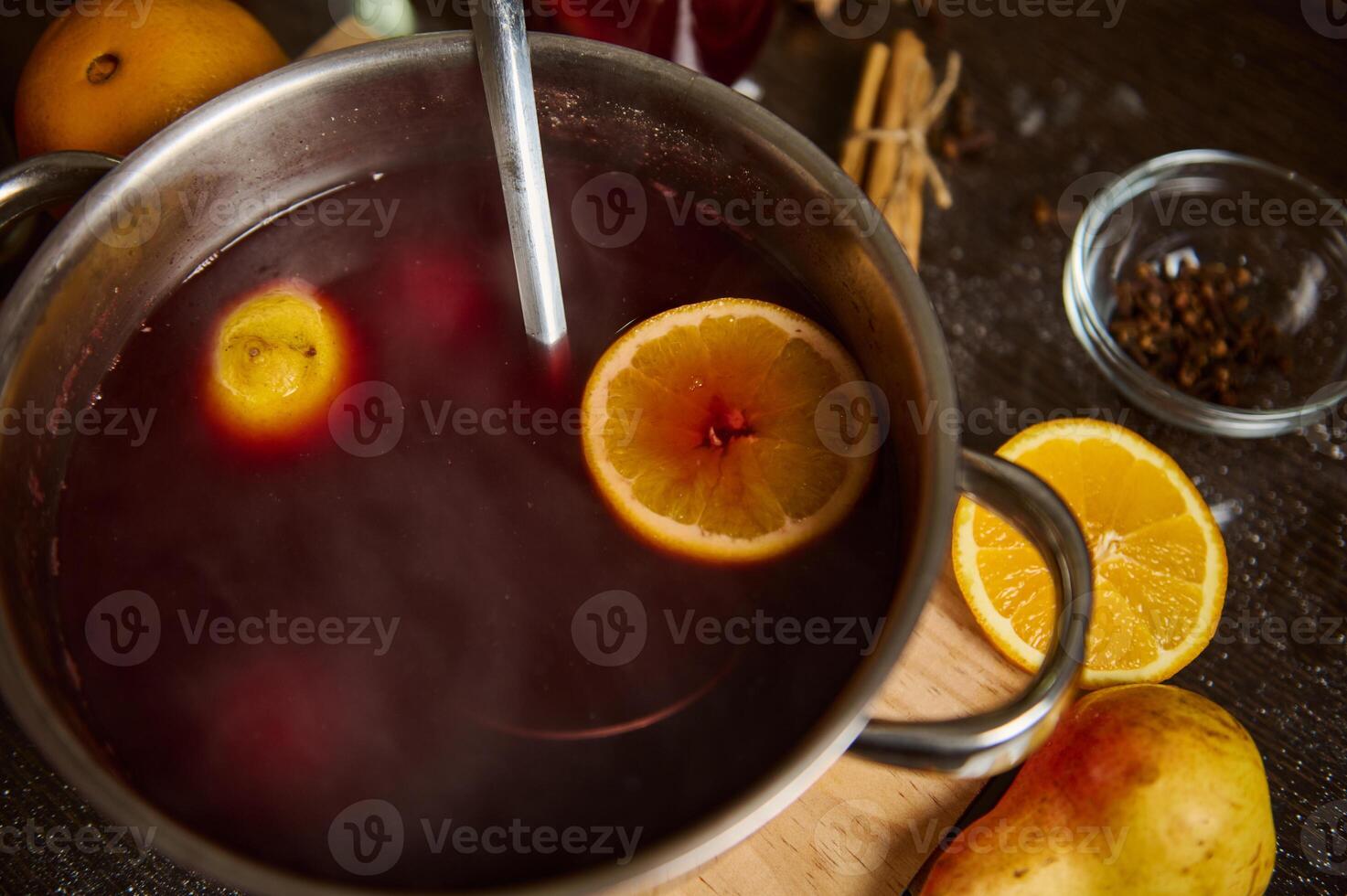 Close-up of spiced mulled wine with fruit and spices in a pot photo