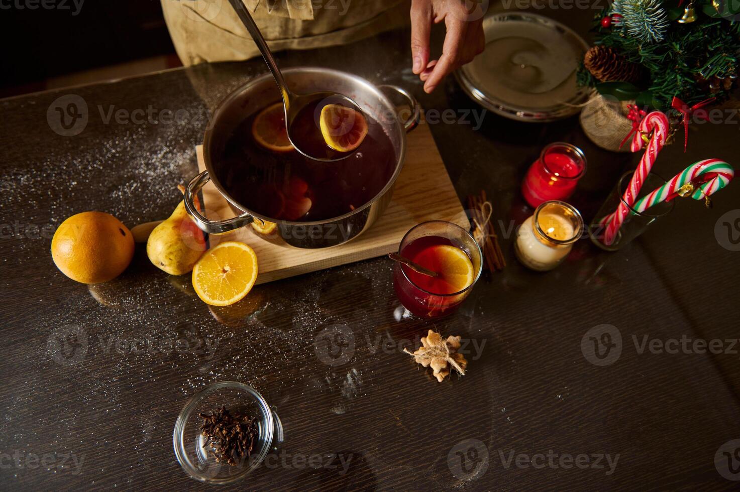 Preparation of hot mulled wine with oranges and spices for Christmas photo