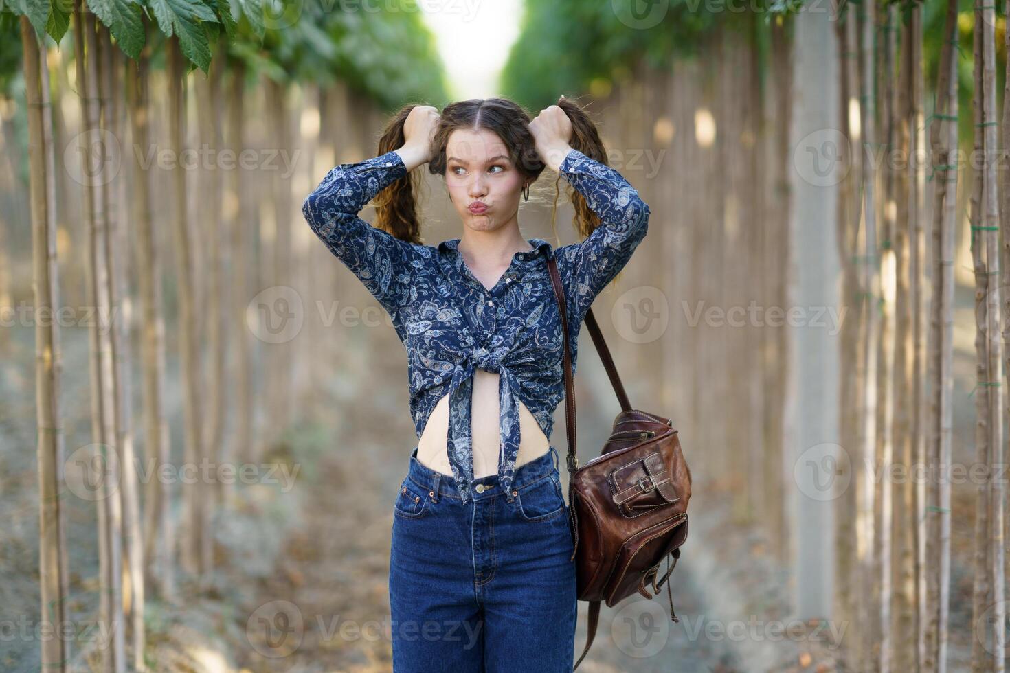A Playful Young Woman Joyfully Posing in a Beautiful Outdoor Vineyard Environment photo