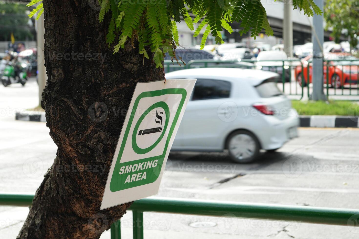Signs symbolize Smoking area on the tree with street background , soft focus, blurred background photo