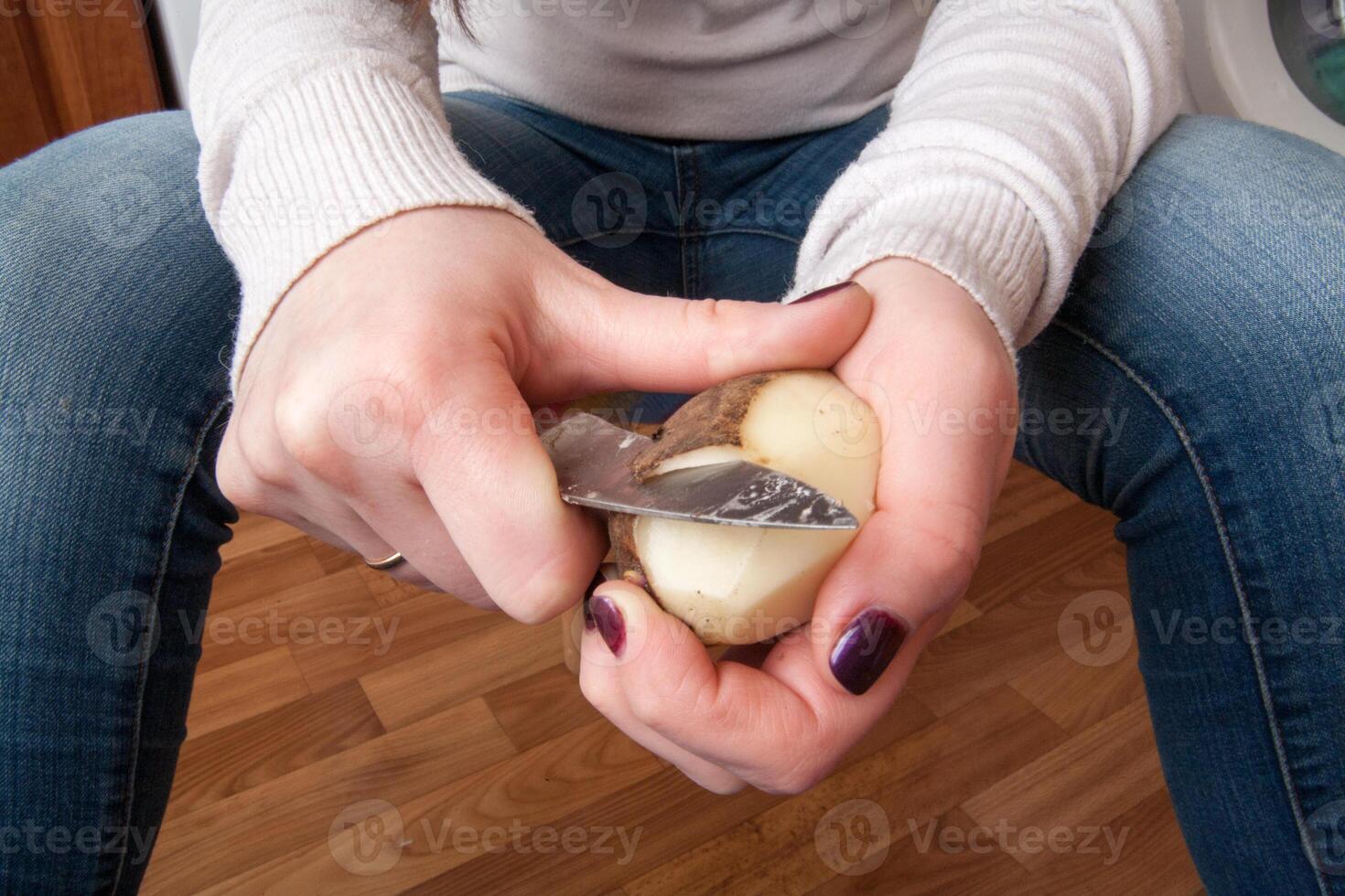 one potato is peeled with a kitchen knife photo