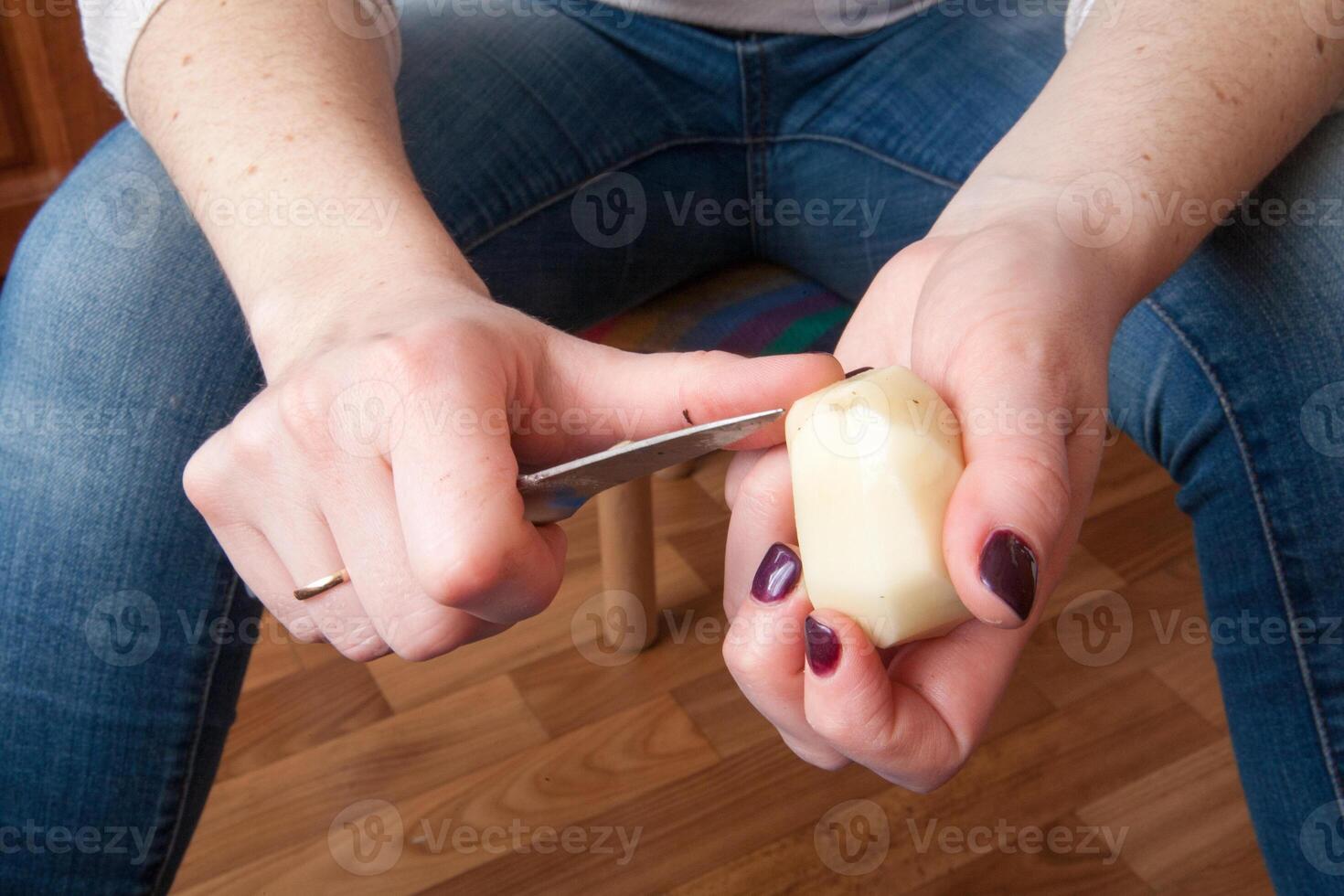 one potato is peeled with a kitchen knife photo