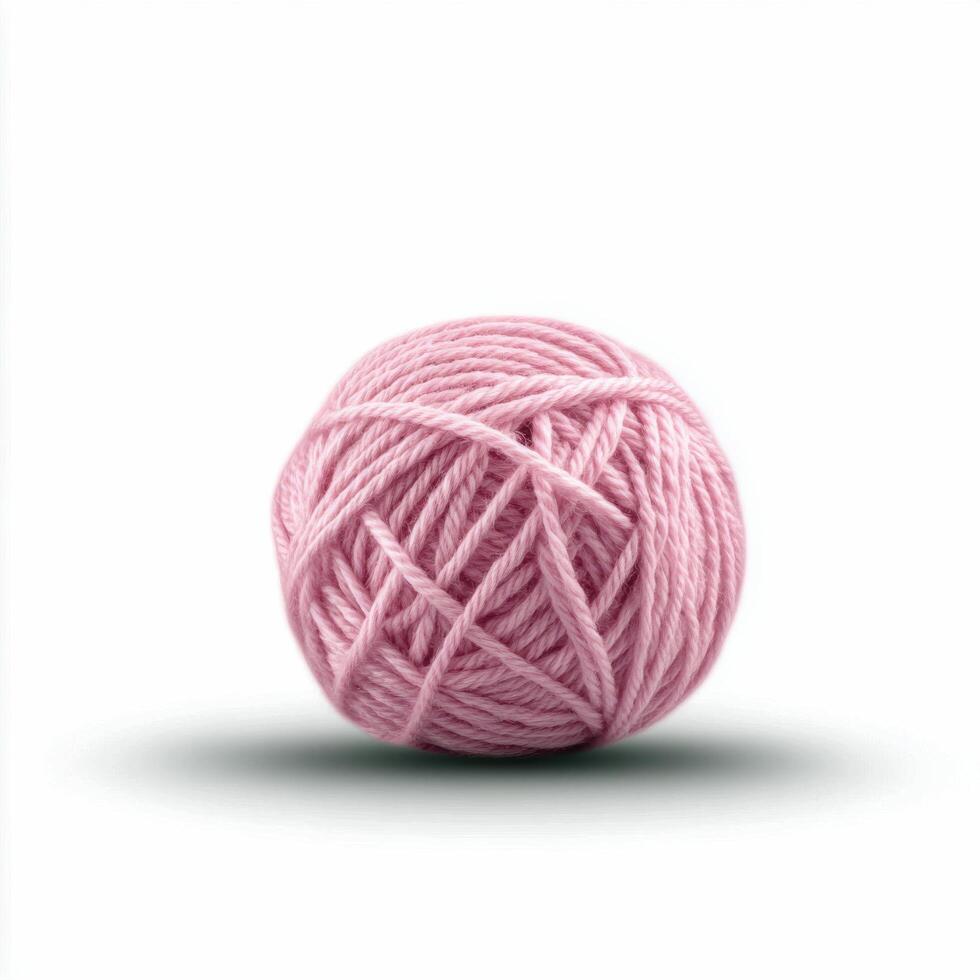 Soft pink yarn ball resting on a light surface with gentle shadow photo