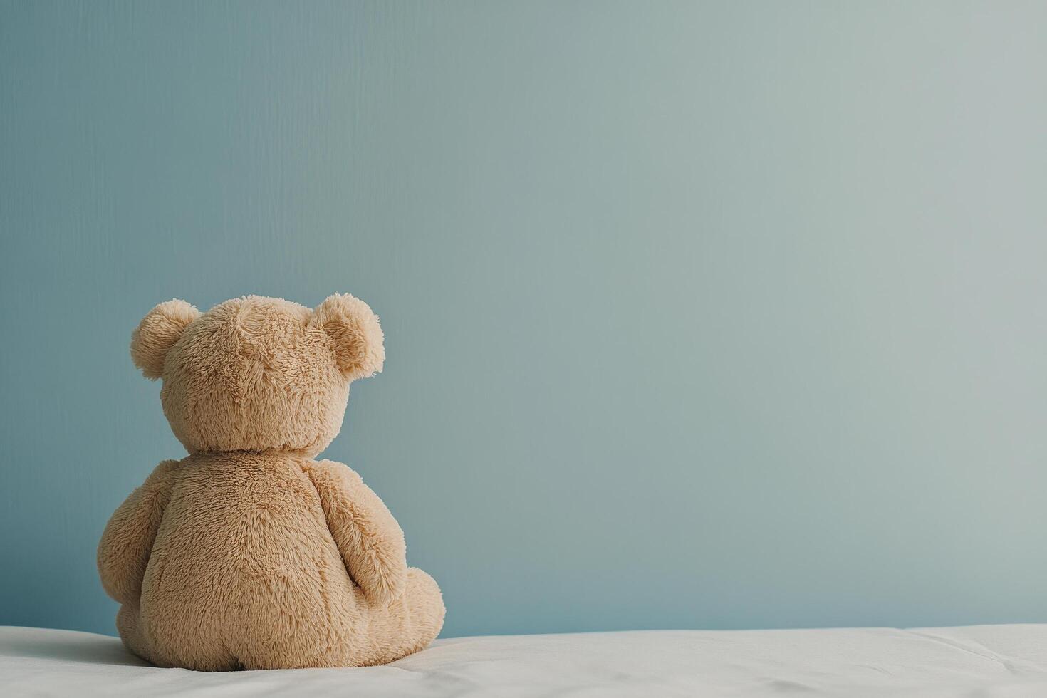 Soft bear gazing out a bright window in a serene bedroom setting photo