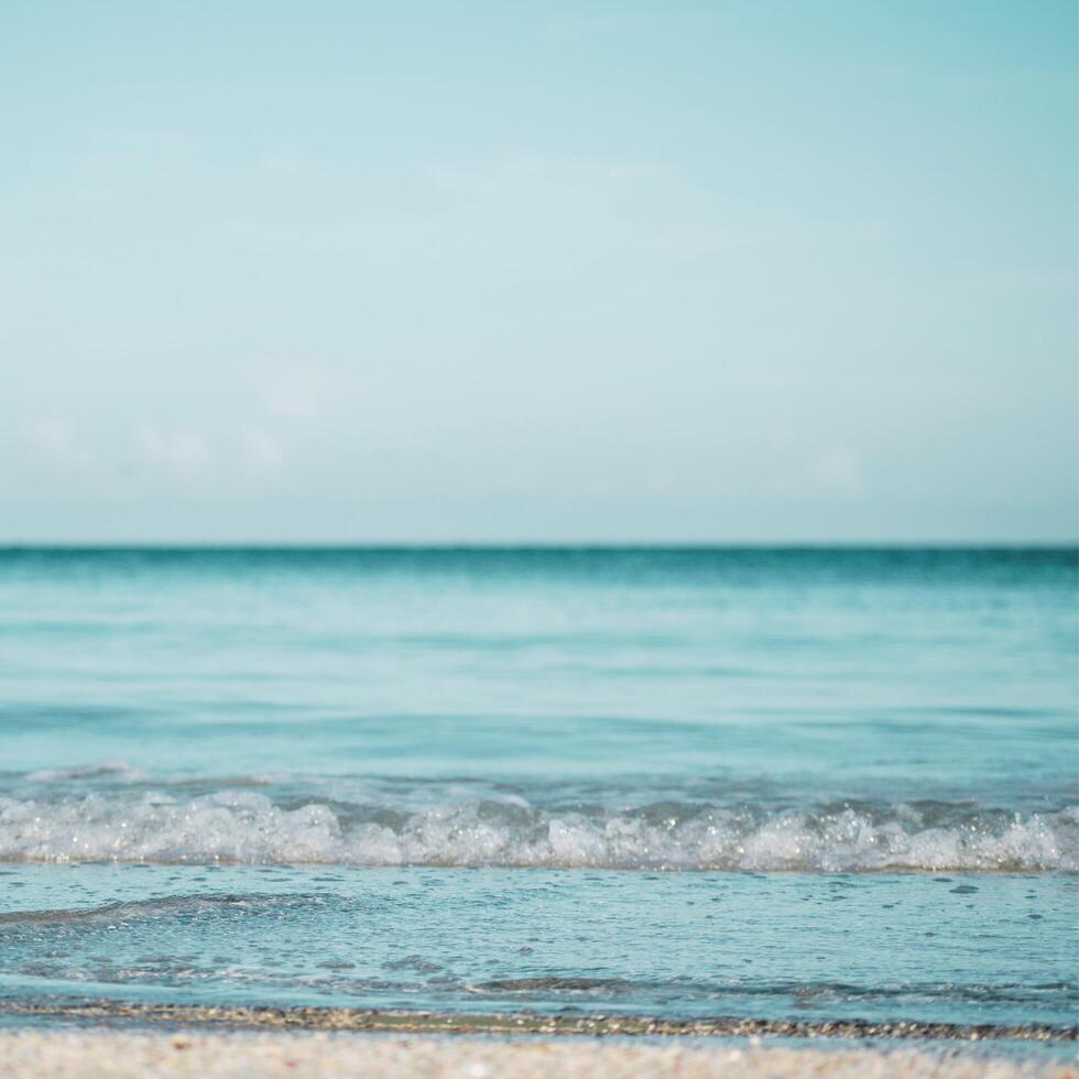 a beach with waves and a blue sky photo