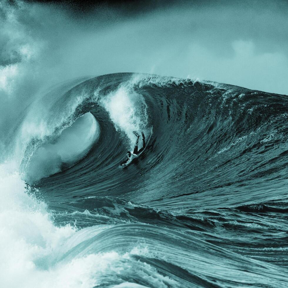 a man riding a wave in the ocean photo
