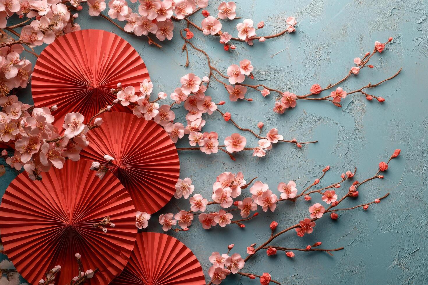 Colorful paper fans and cherry blossoms create a vibrant decorative display on a blue background photo