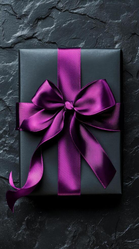 Elegant black gift box with purple ribbon ready for a special occasion photo