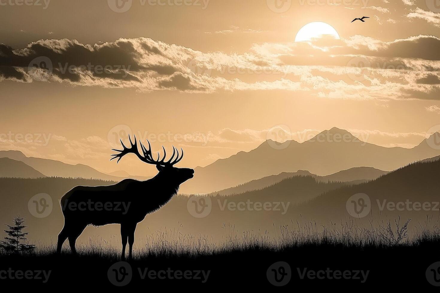 A silhouette of a deer standing in front of mountains photo
