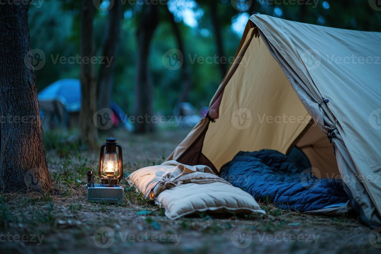 A tent and a lamp are set up in the woods photo