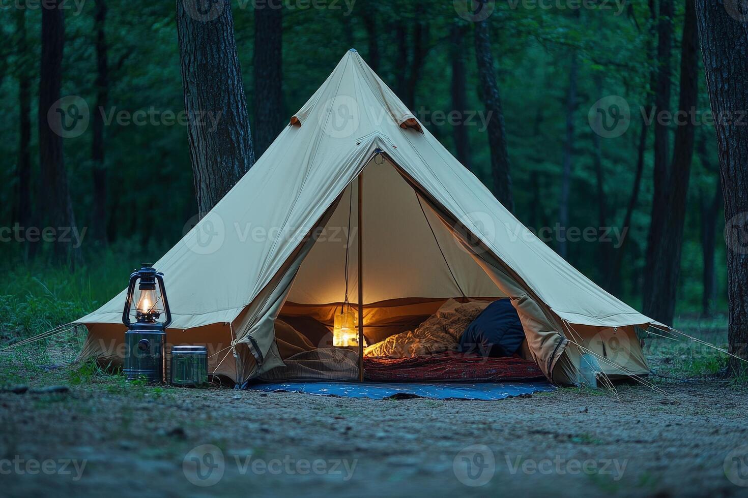 A tent in the woods with a light on photo