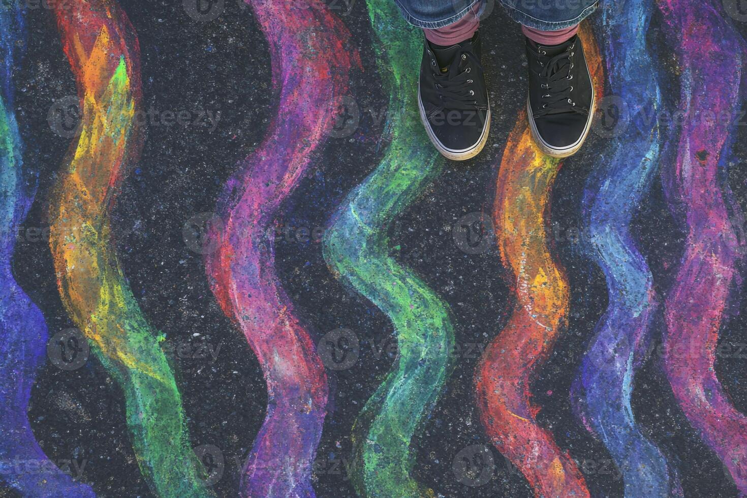 A person standing on a sidewalk with colorful chalk photo
