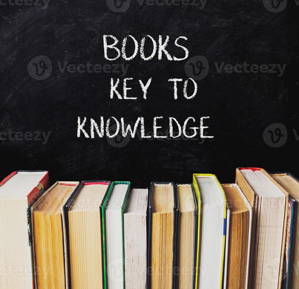 A chalkboard with a stack of books on it photo