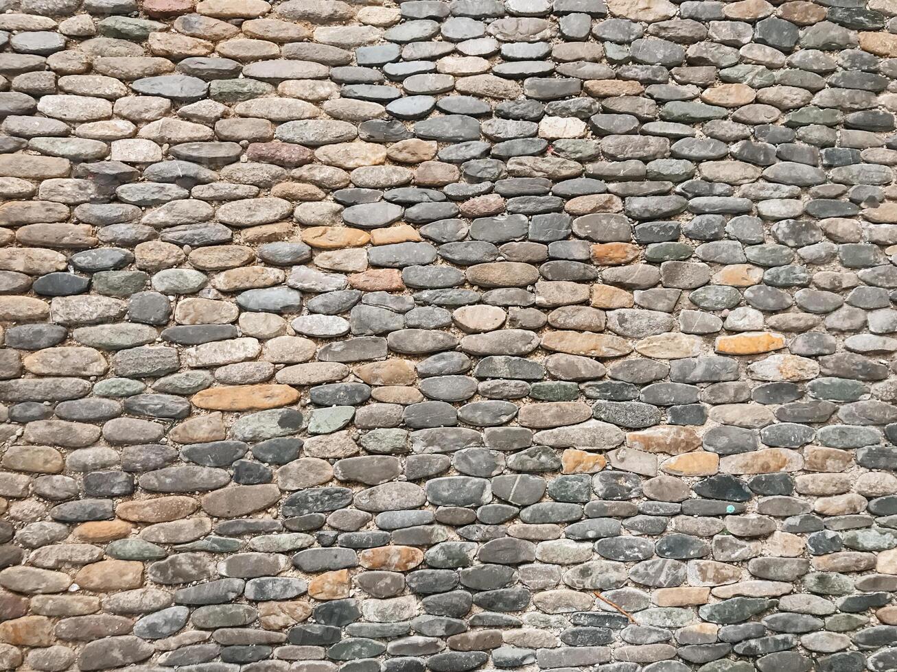 A wall made of stone blocks with a brown and gray color photo
