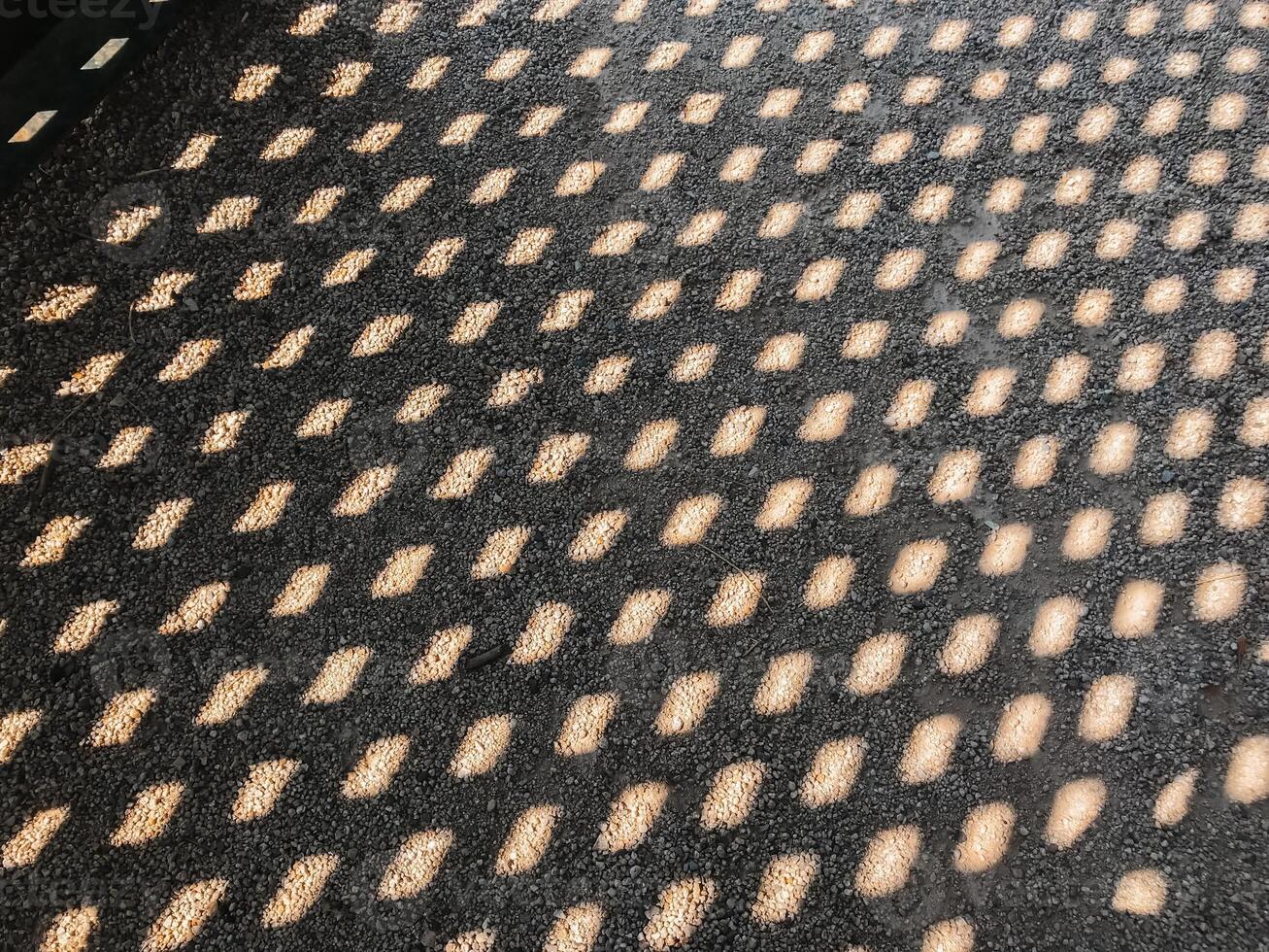 A black and white photo of a road with a pattern of small squares