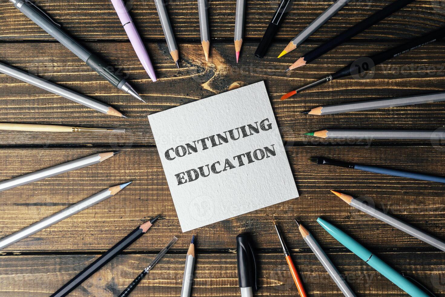 Circle of pencils and pens with the word continuing education written in the center photo
