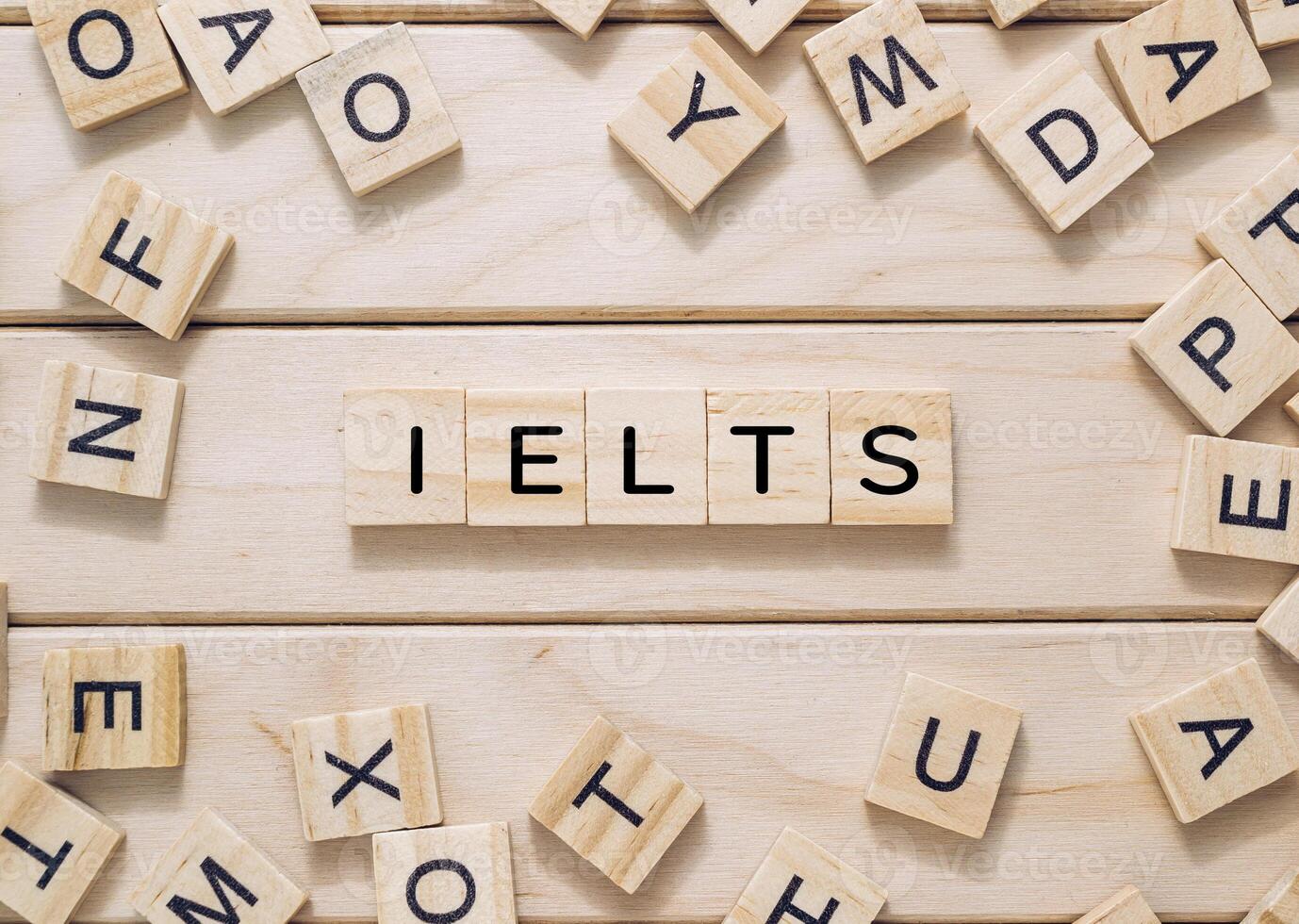 The image features a collage of wooden blocks spelling out IELTS photo