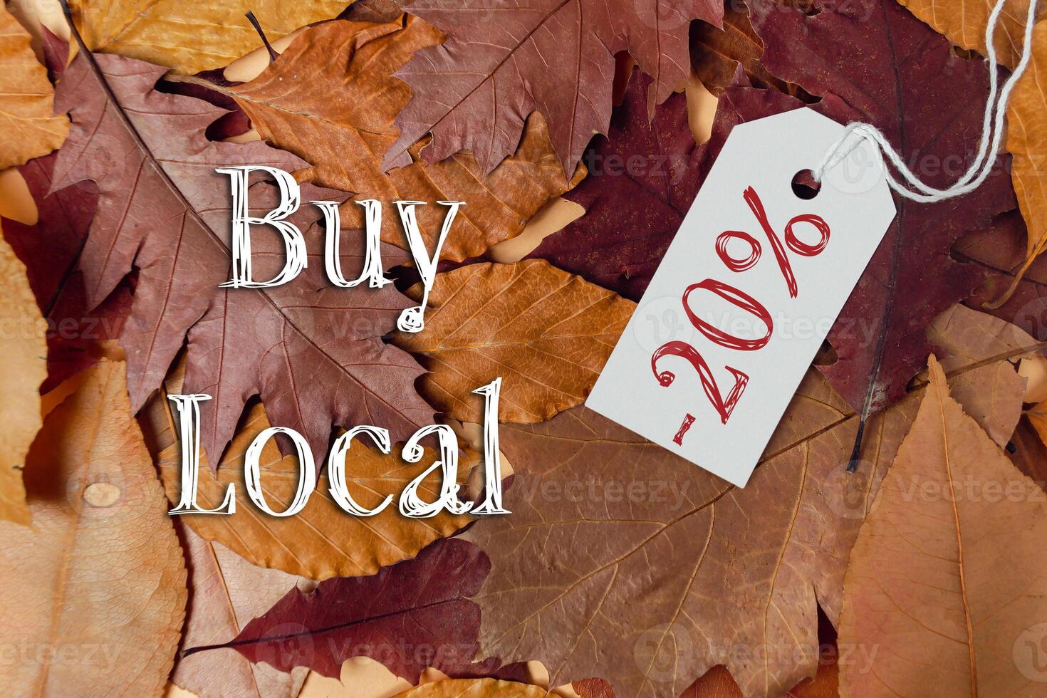 Tag with the word buy is hanging from a pile of leaves photo