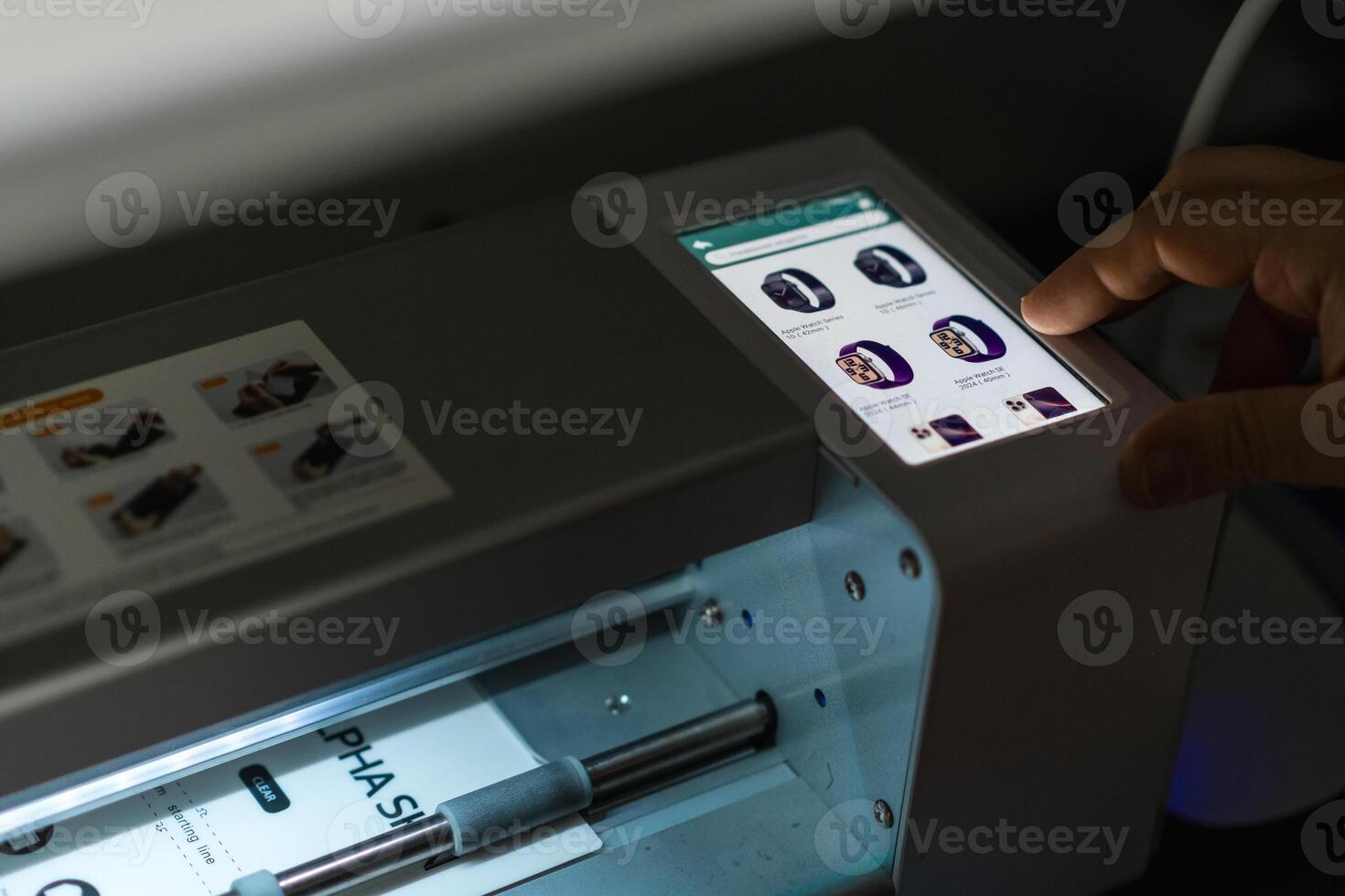 User interacts with a precise plotter for cutting hydrogel film in a modern workspace during the day photo