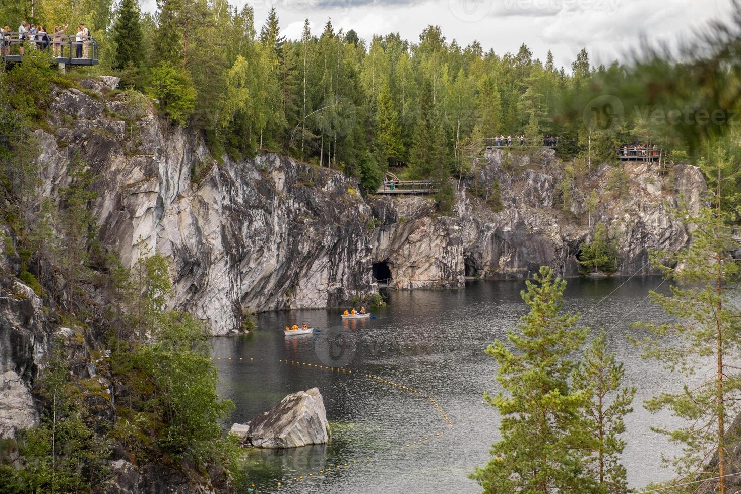 Guests enjoy the natural beauty of Marble Canyon in Karelia, surrounded by lush trees and calm waters while taking in the breathtaking views photo