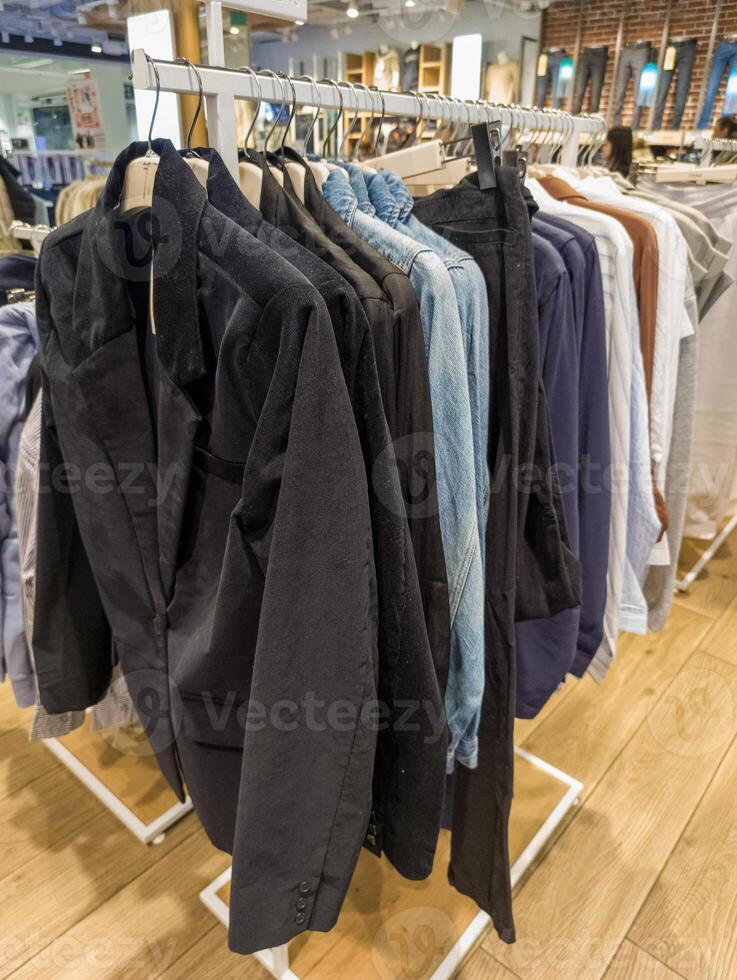 A rack of clothes hanging on a rack in a clothing store photo
