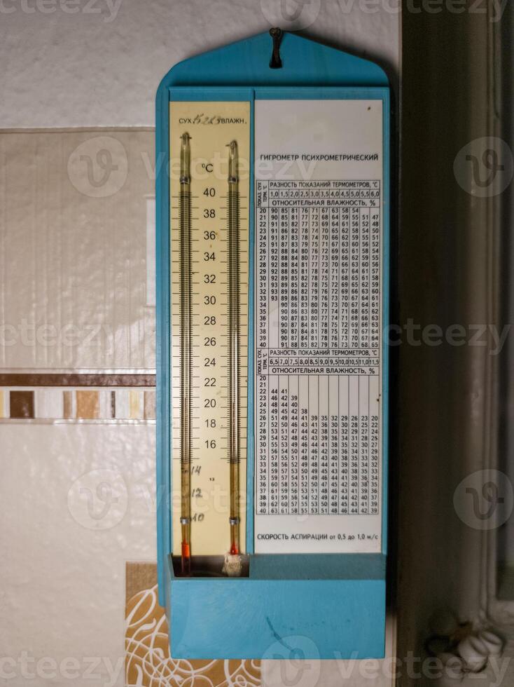 Thermometer, hygrometer hanging on the wall next to the window photo