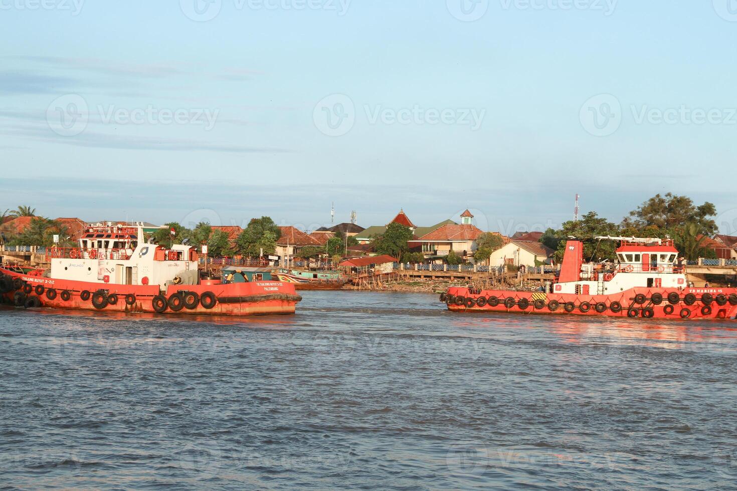 tugboat pulling a heavily laden coal barge sailing on the Musi River. photo