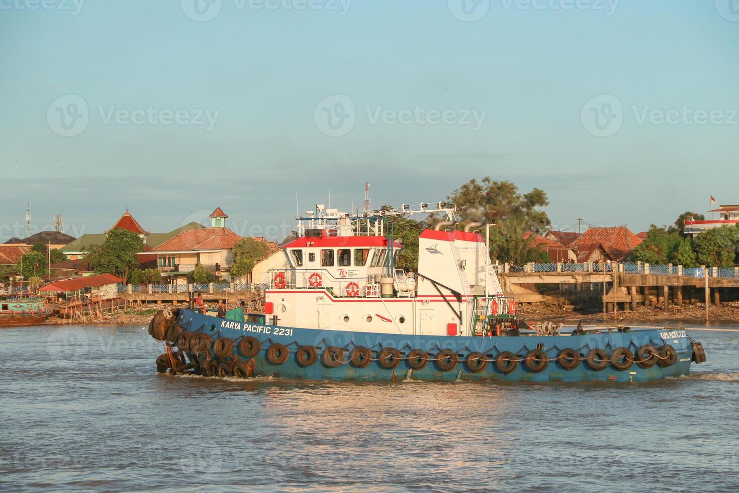 tugboat pulling a heavily laden coal barge sailing on the Musi River. photo