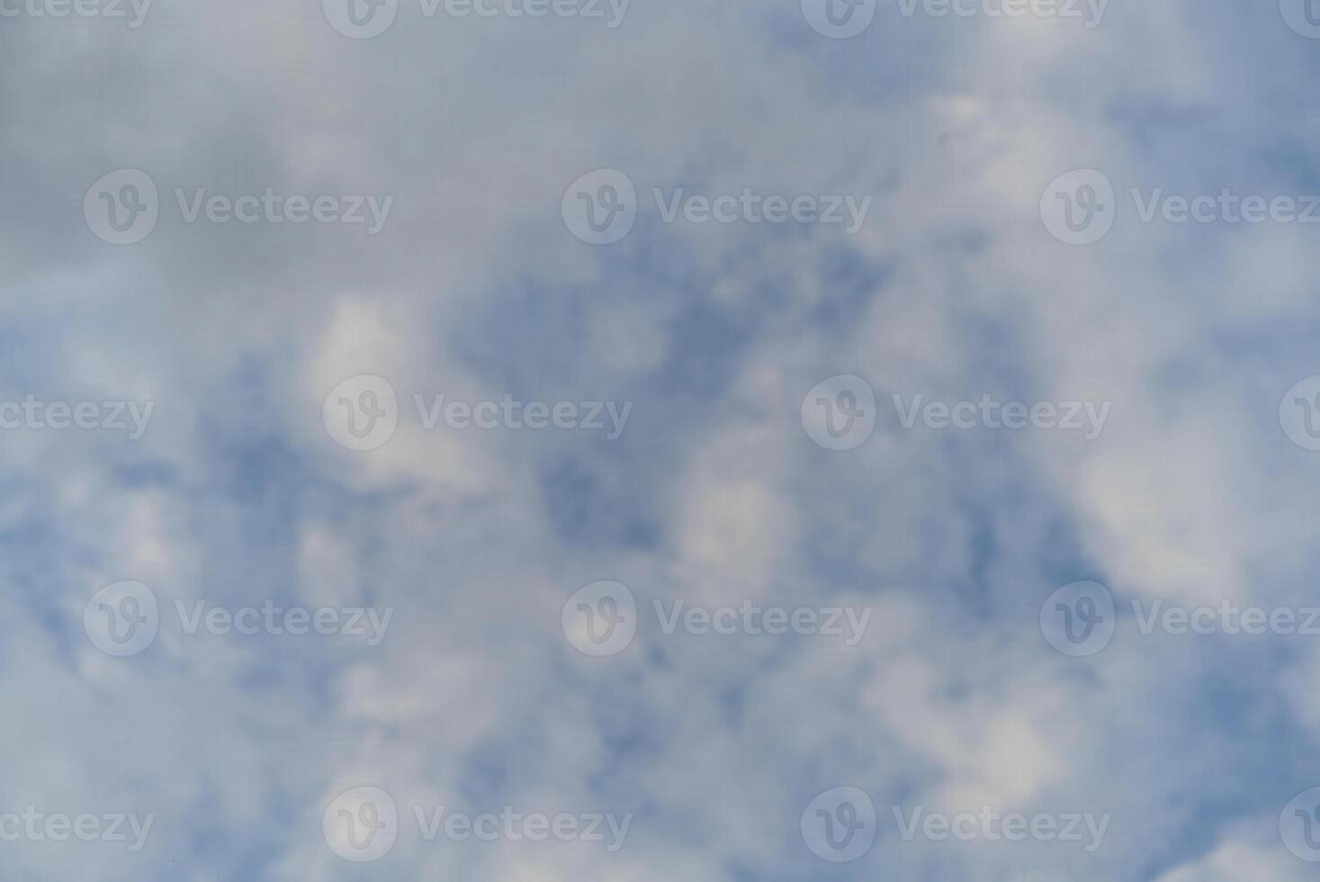 A plane flying through the sky with some clouds photo